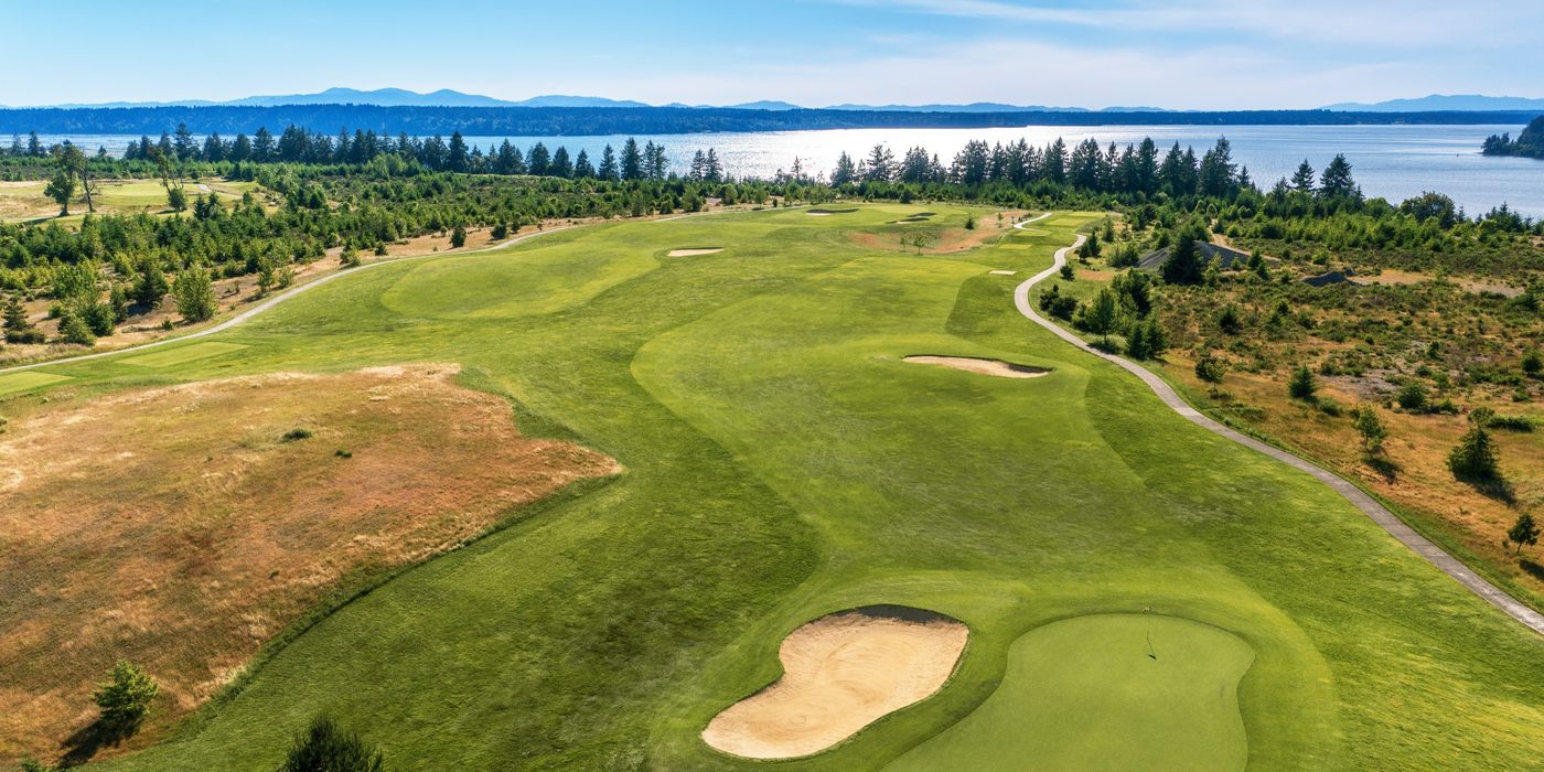 A parkland green and bunkers above the water at The Home Course in Washington